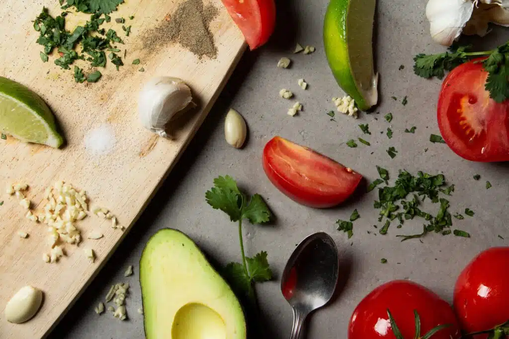 guacamole ingredients - avocados, tomatoes, fresh garlic, cilantro