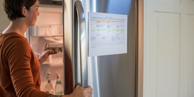 cropped image of woman grabbing egg carton out of refrigerator