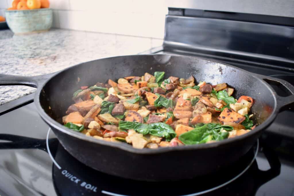 chopped potatoes and sausage in a cast iron pan