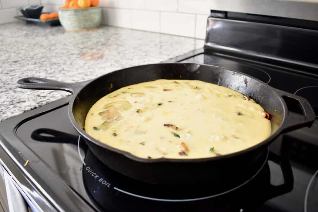 raw frittata before baking in a cast iron pan