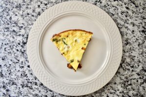 slice of cooked frittata on white circular plate