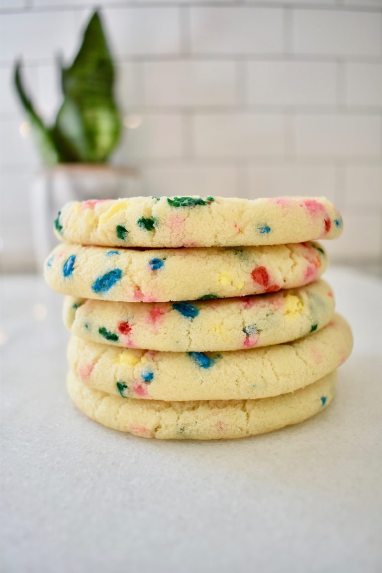 Funfetti cookies arranged in a stack in vertical image