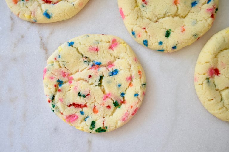 giant funfetti cookies laid out on white countertop