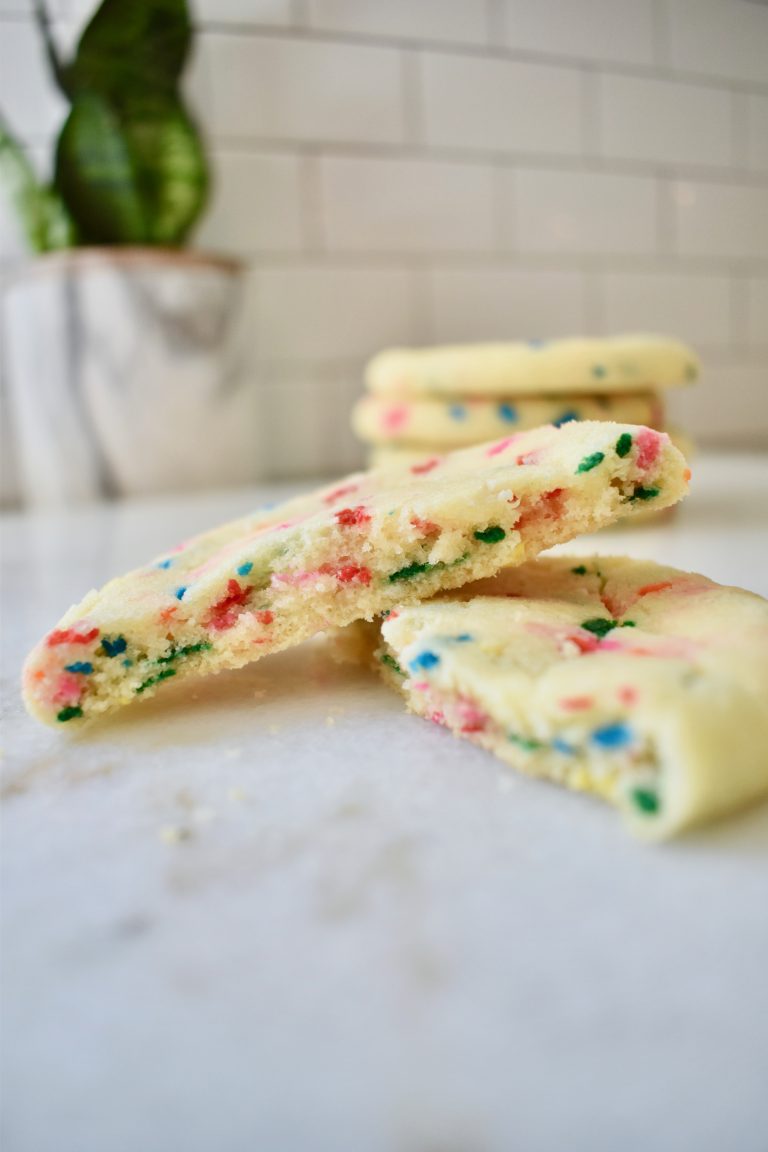 Side view of funfetti cookies, broken in half to expose the soft middle