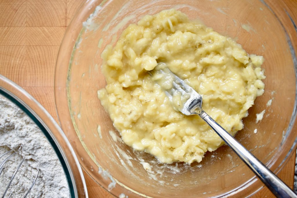 overhead shot of mashed bananas in a glass bowl