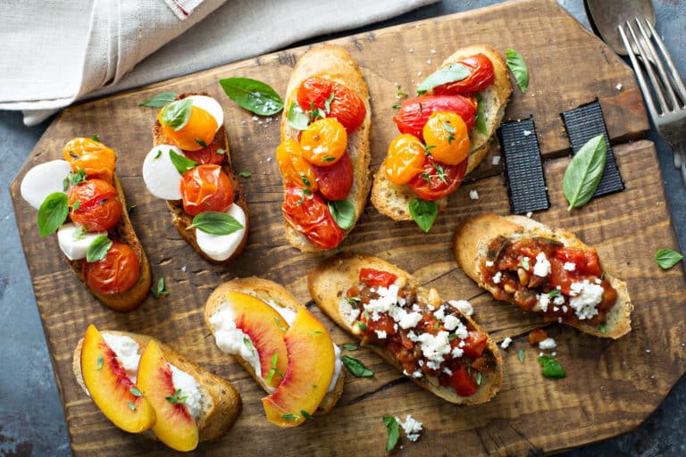 Crostini or bruschetta board with caprese, tomatoes, eggplant caponata and peaches