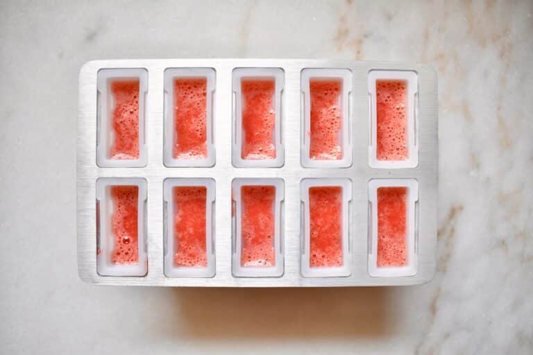 overhead shot of popsicle molds filled with strawberry puree