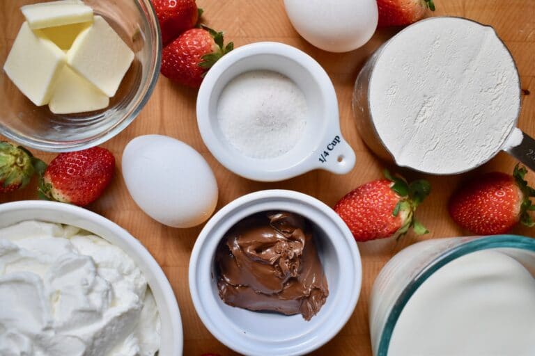 overhead shot of ingredients for crepes, portioned in separate bowls