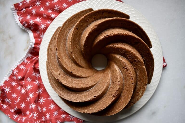 overhead shot of spiced bundt cake with a red holiday napkin on a white surface