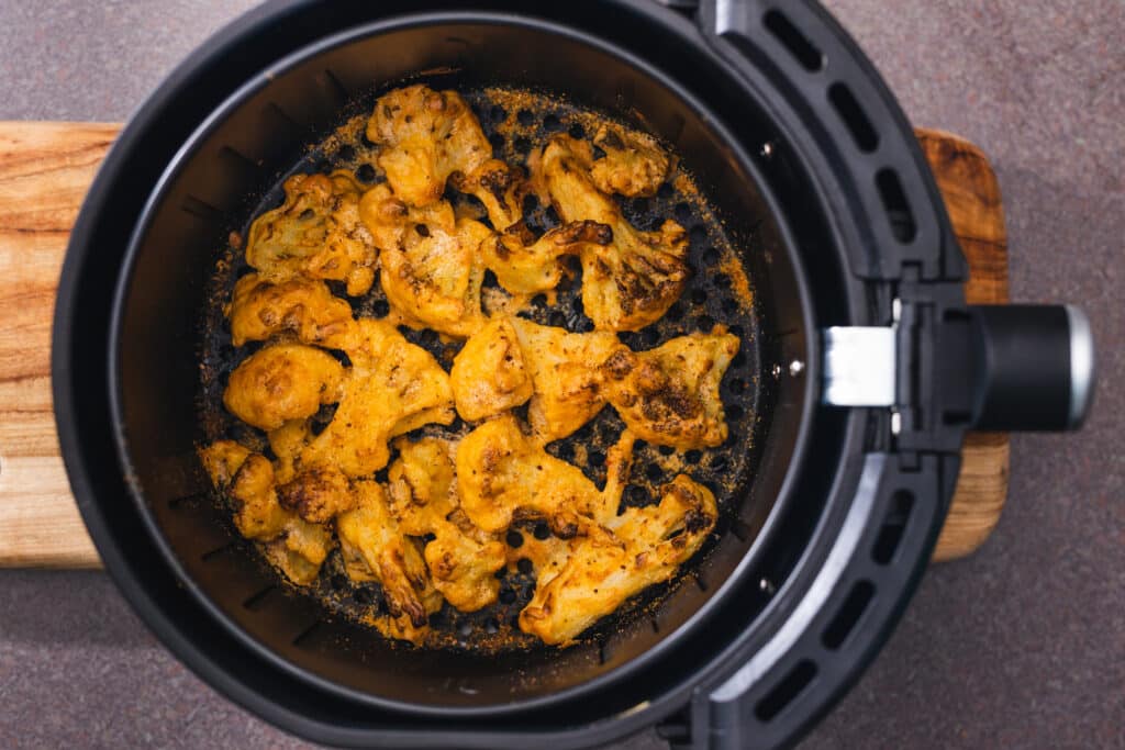 overhead shot of cauliflower florets in an air fryer