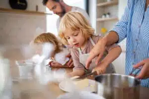 close up of young child helping to cut butter in the kitchen