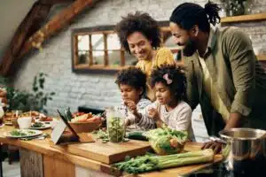 young family of four gathered in the kitchen to cook dinner