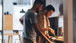 two men cooking together in a small kitchen
