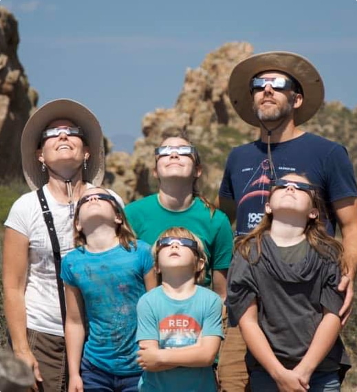 young Bounds family watching the solar eclipse with special eclipse glasses