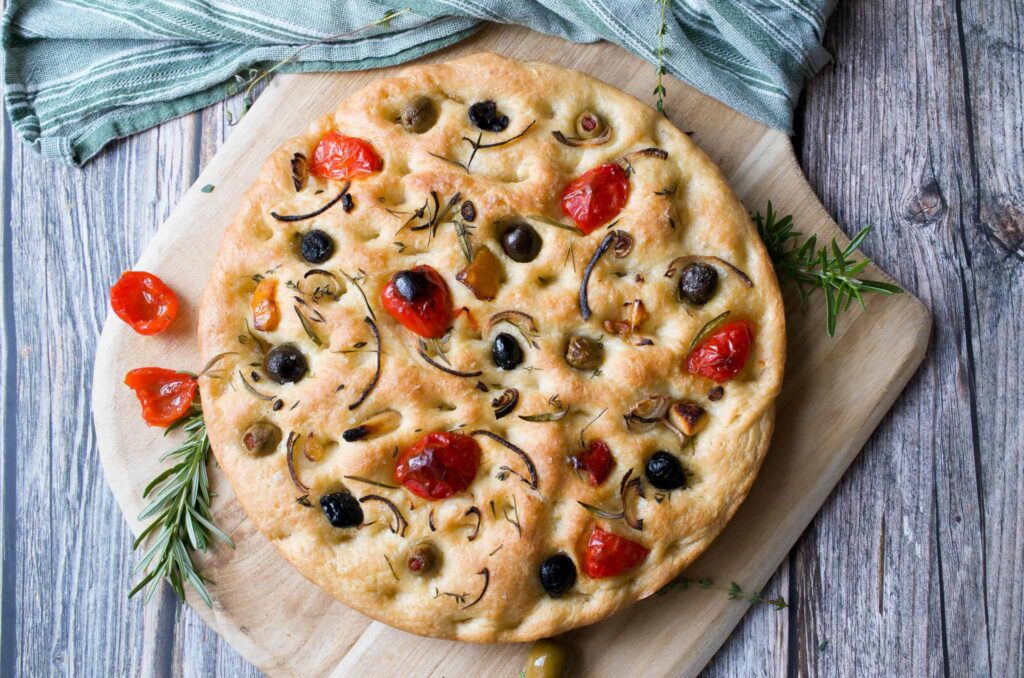 straight overhead shot of focaccia bread with olives on a cutting board