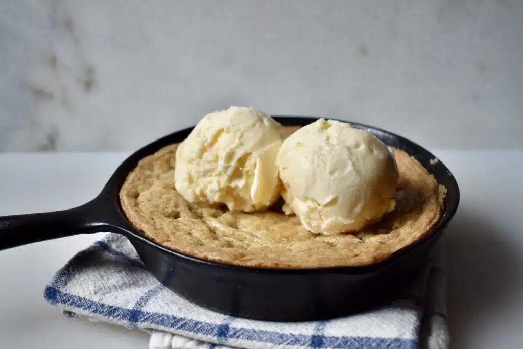 pizza cookie in a skillet with two scoops of vanilla ice cream