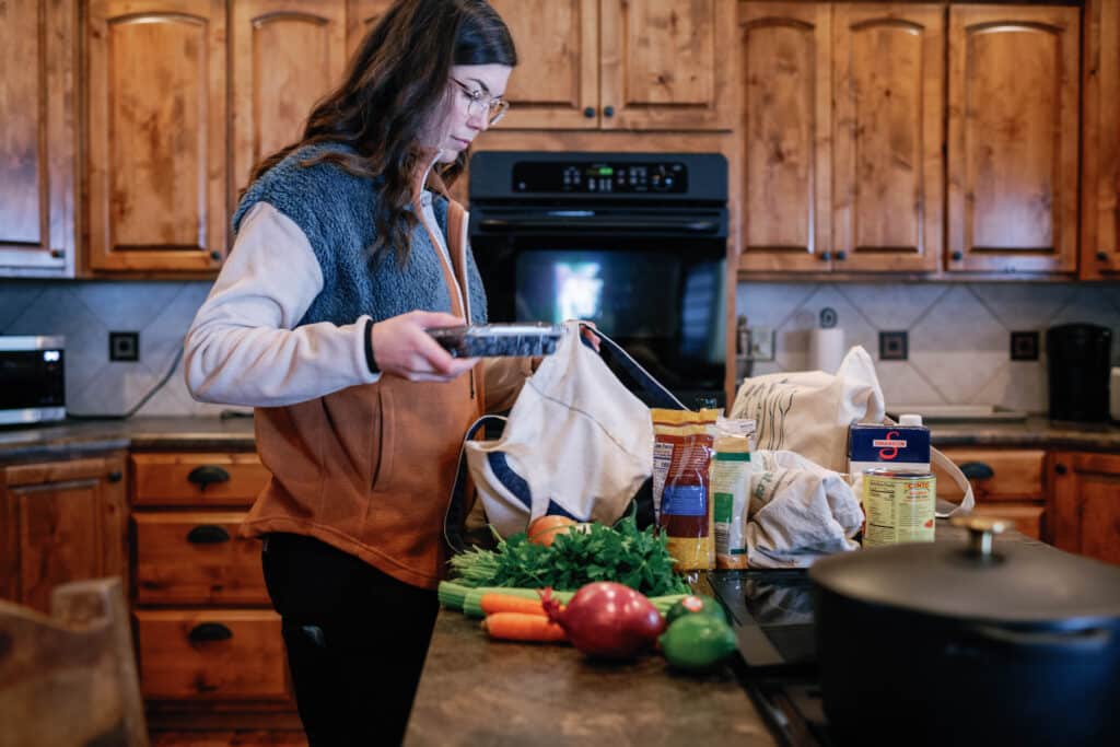 image of woman unloading groceries onto kitchen counter