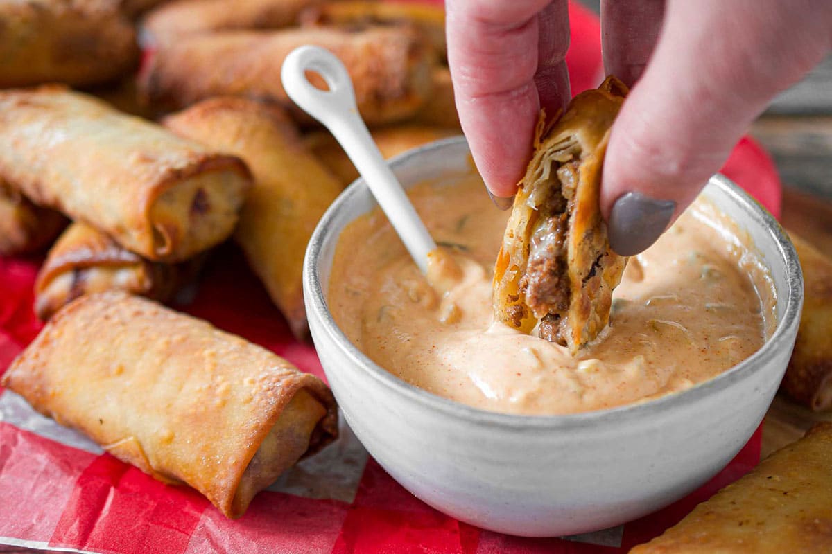 close up of dipping an egg roll into the sauce