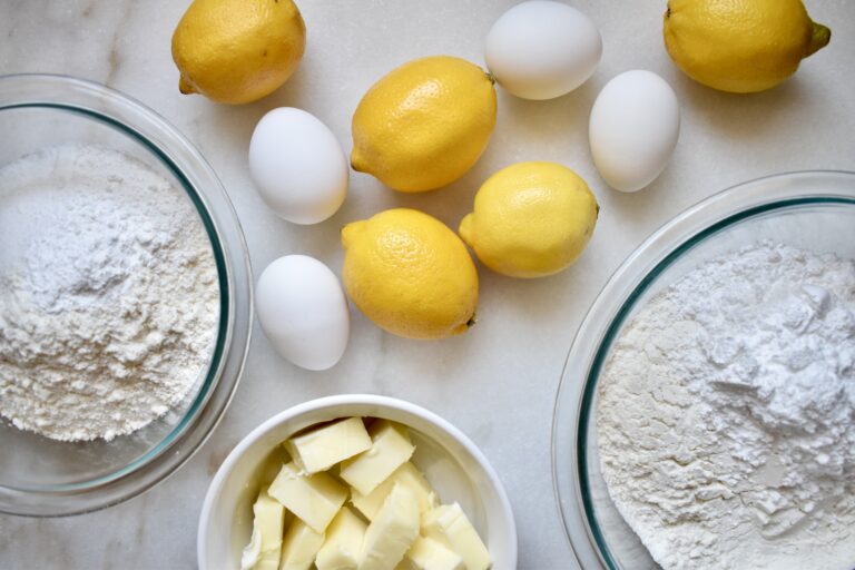 overhead shot of lemons, eggs, butter, sugar, and flour mise en place for lemon squares recipe