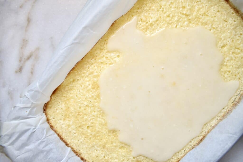 overhead view of lemon bar crust with partially poured glaze on top