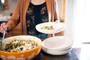 cropped image of woman scooping salad into a bowl
